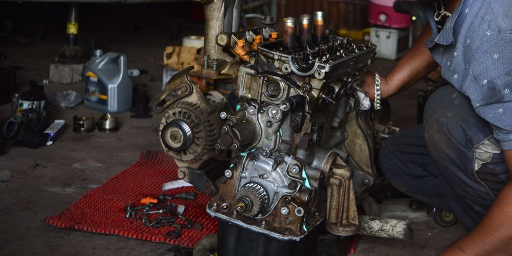 Mechanic repairing a car engine in the workshop